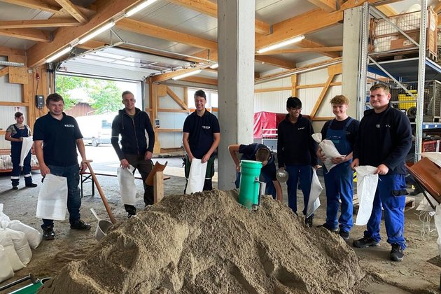 Berger Azubis befüllen Sandsäcke